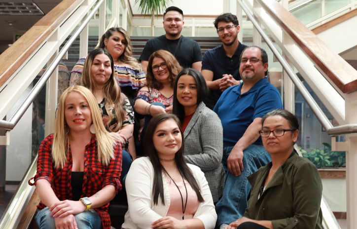 ten people from diverse backgrounds sitting on a staircase